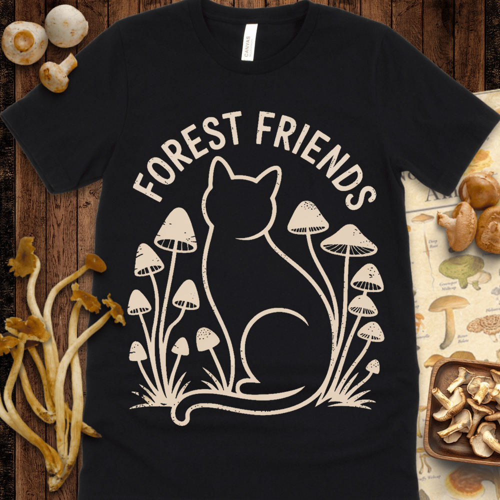 T-shirt design featuring the silhouette of a cat surrounded by tall mushrooms, with the text “Forest Friends” above, all in soft beige on a black background.