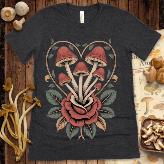 Tattoo-style illustration of red mushrooms growing from a rose, framed by a vine heart with green leaves