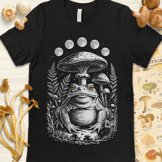 Illustration of a toad sitting beneath large mushrooms with all moon phases above, surrounded by ferns in a fantasy forest setting.