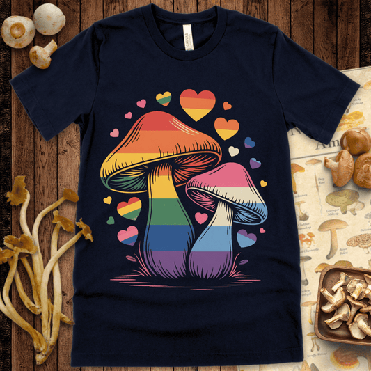 Two mushrooms with rainbow and transgender flag colors surrounded by colorful hearts in a hand-drawn, pride-themed design on black background